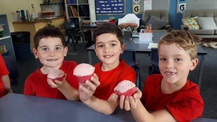 school students with red cakes
