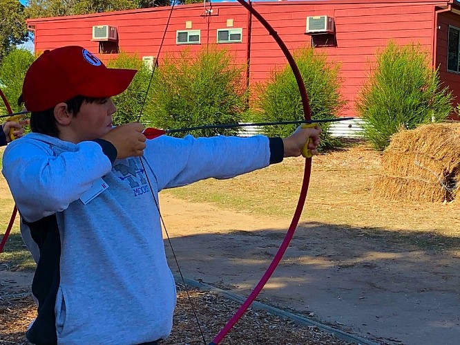 Bailey at archery during camp