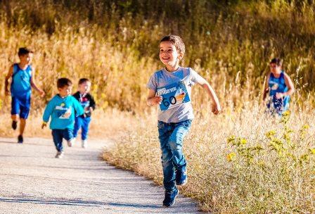 boy running on pathway and smiling