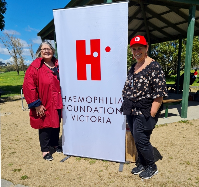 2 women in front of Haemophilia Foundation Victoria stand