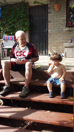older man in bike gear talking to his grandson