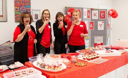 Staff at Calvary Mater eating red cakes at their stall