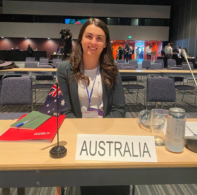 Shauna seated at a table with the Australian flag