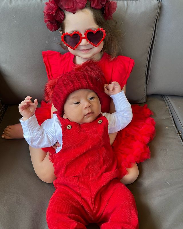 little girl and baby brother dressed in red