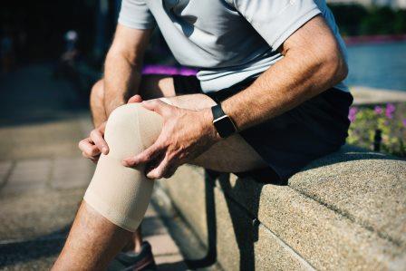 man's knee with strapping - photo Rawpixel from PEXELS