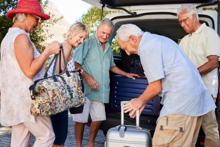 seniors loading suitcases into van