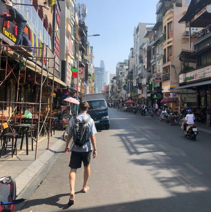 Young man walking along a street in Vietnam