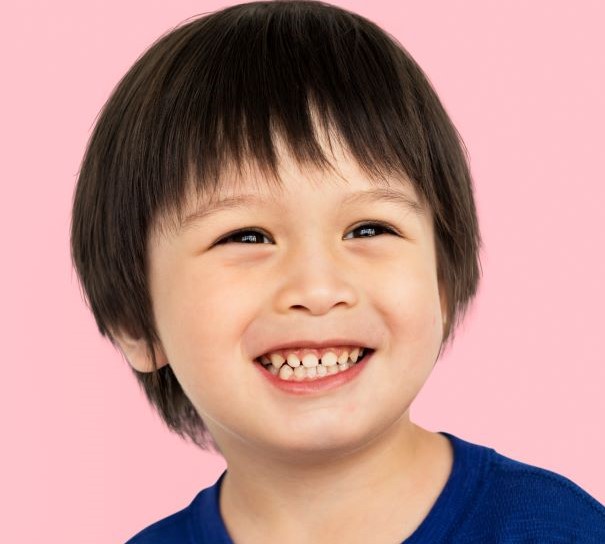 small boy smiling and showing his teeth - photo by rawpixel.com for freepik